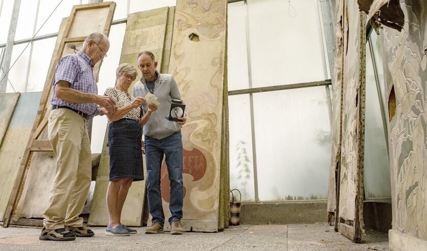 Aad en Toni van der Meer samen met Marcel van Dien druk bezig om aan de hand van foto's de juiste volgorde van de panelen te bepalen (Foto: Roel van Dorsten)
