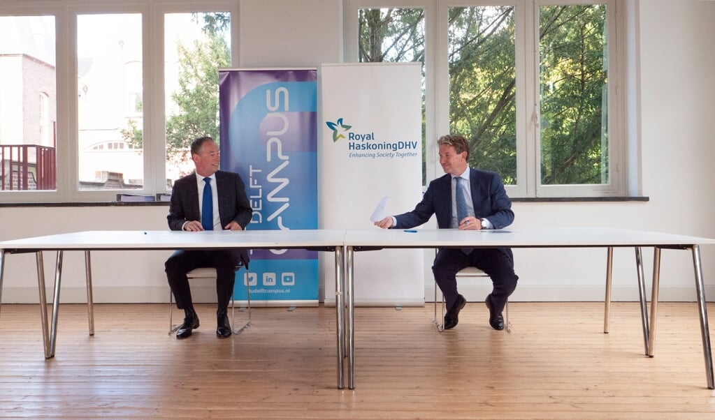 Tim van der Hagen, voorzitter van de TU Delft (links), en Erik Oostwegel, CEO van Royal HaskoningDHV, ondertekenen het Memorandum of Understanding (Foto: TU Delft / Jens Kok)