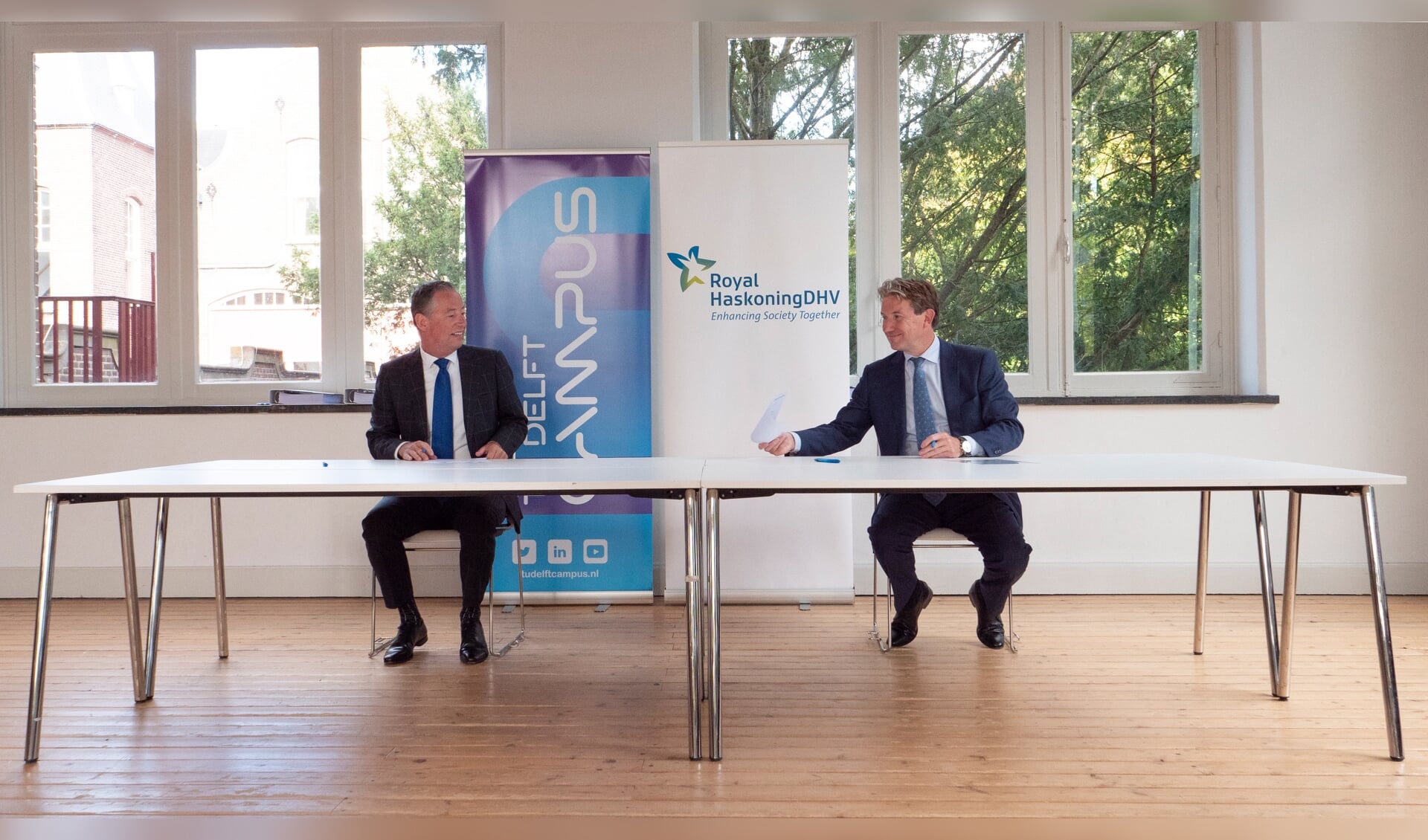 Tim van der Hagen, voorzitter van de TU Delft (links), en Erik Oostwegel, CEO van Royal HaskoningDHV, ondertekenen het Memorandum of Understanding (Foto: TU Delft / Jens Kok)
