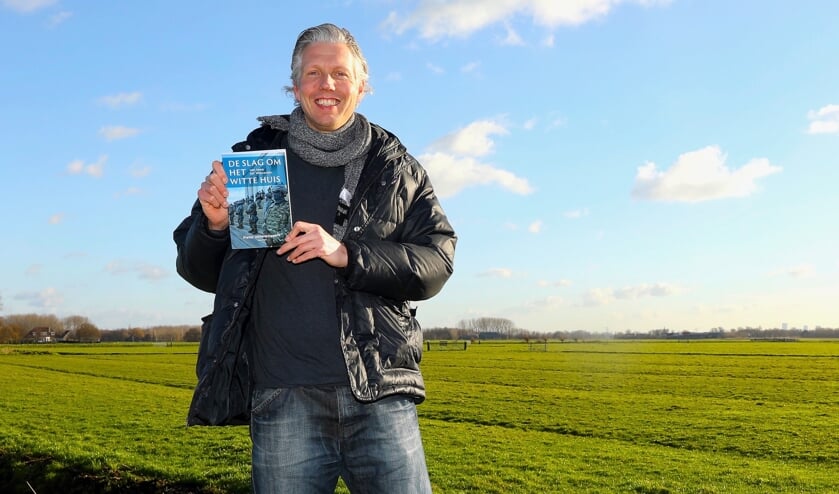 <p>Pieter Uittenbogaard met zijn recent verschenen boek op een van de mooiste plekjes van Delft. Foto: Koos Bommel&eacute;</p>  