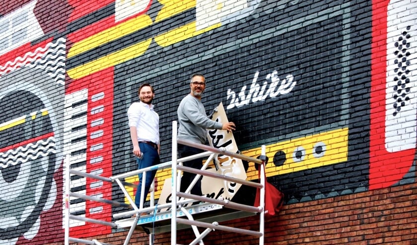 <p>Wethouder Bas Vollebregt en kunstenaar Micha de Bie leggen de laatste hand aan het kunstwerk (Foto: Koos Bommelé)</p>