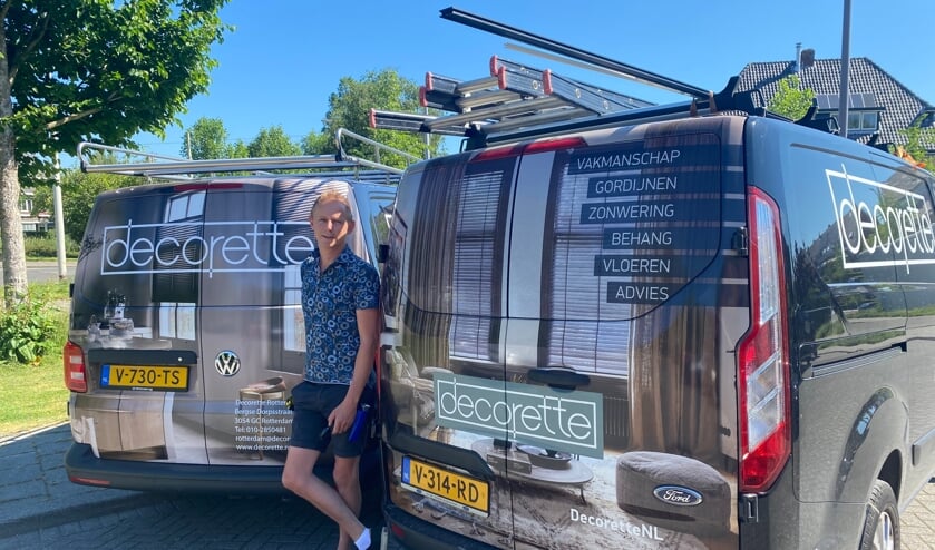 <p>Eigenaar Corné bij de auto's die hij liet bestickeren.</p>