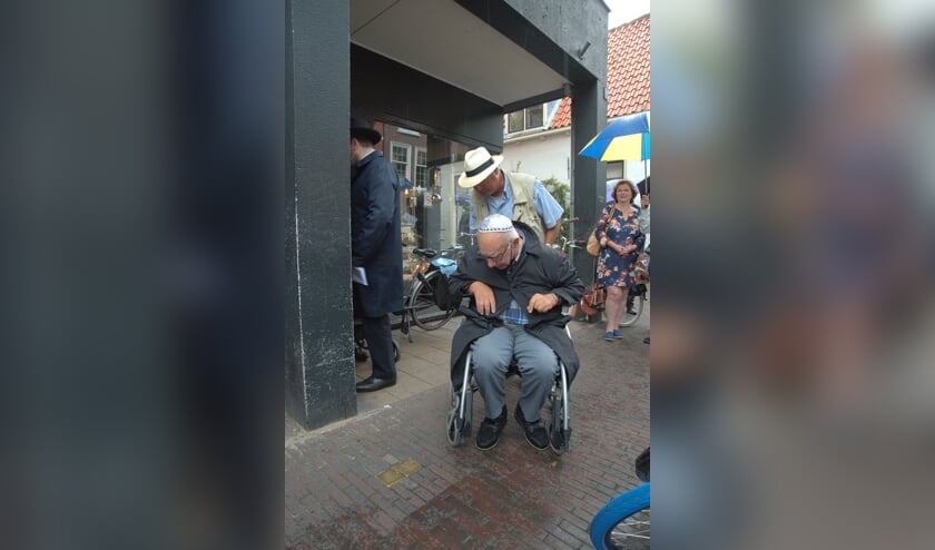 <p>Pum van IJssel (zittend) bekijkt de struikelstenen in de Choorstraat waarmee zijn ouders herdacht worden. (Foto: Hans Roode) </p>