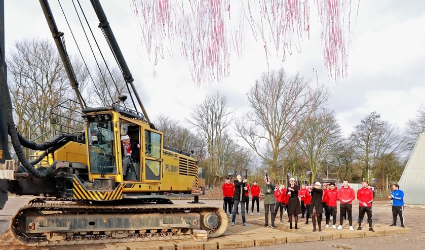 <p>Terwijl de clubleden haar aanmoedigen slaat wethouder Schrederhof de eerste paal. (Foto: Koos Bommelé)</p>