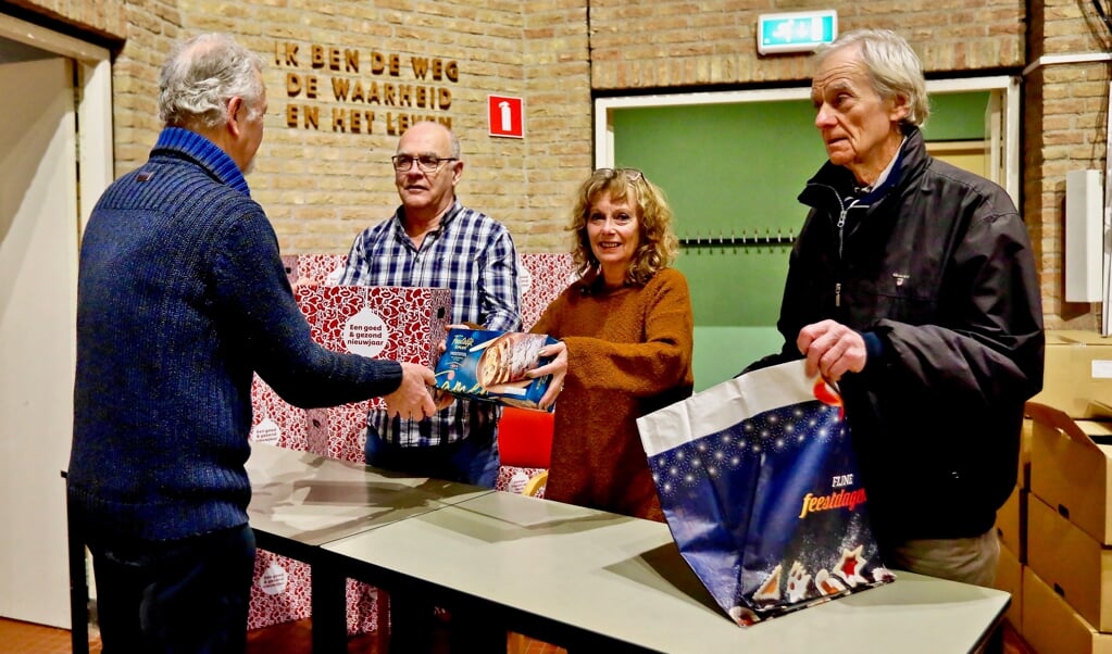 Vrijwilligers van Voedselbank Delft delen kerstpakketten uit
