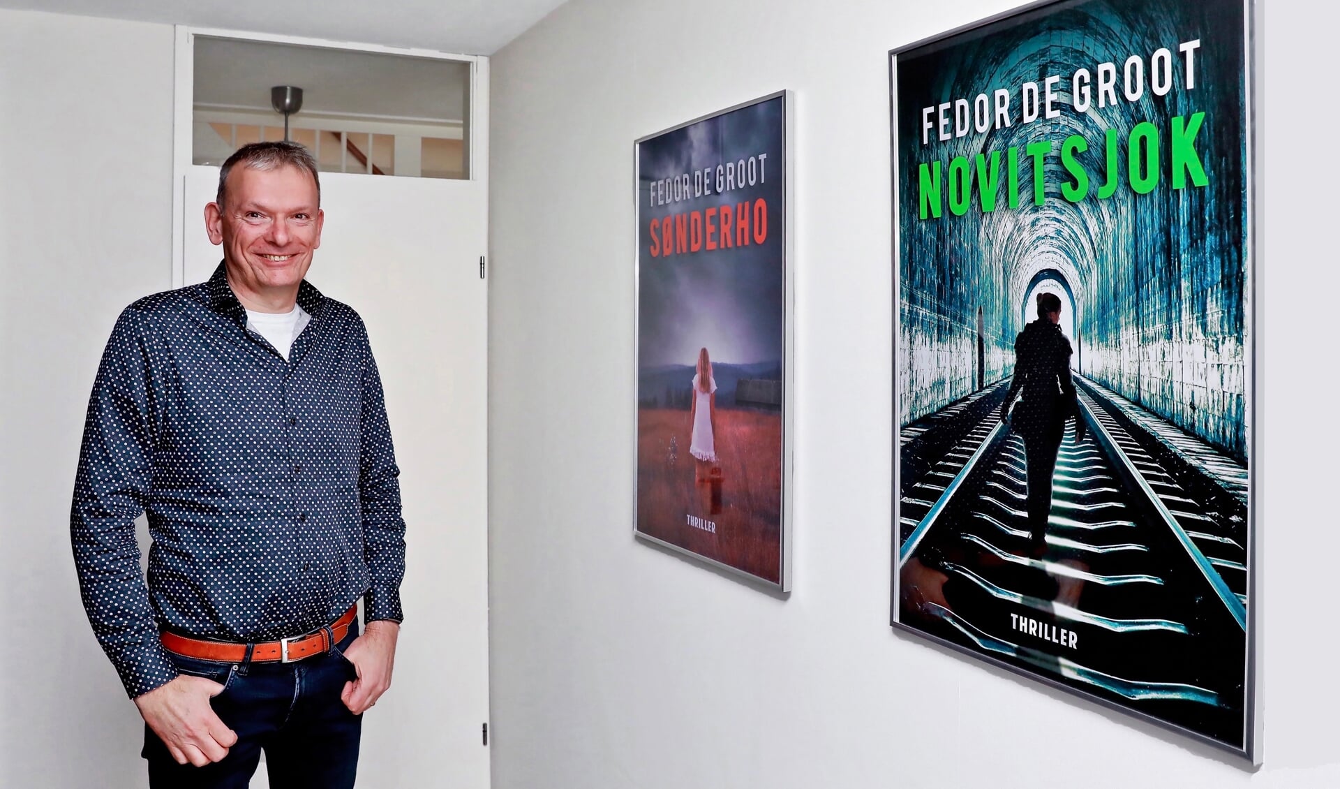 Fedor de Groot bij de coverposters van zijn twee boeken (Foto: Koos Bommelé)
