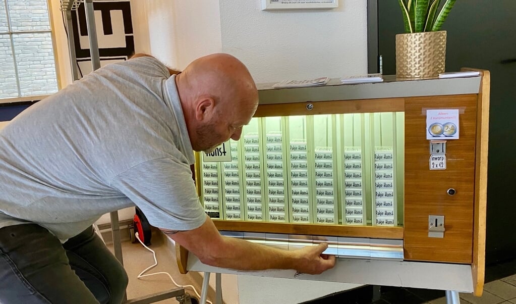 Kunstenaar Joost Konings probeert de Pakje Kunst-automaat uit
