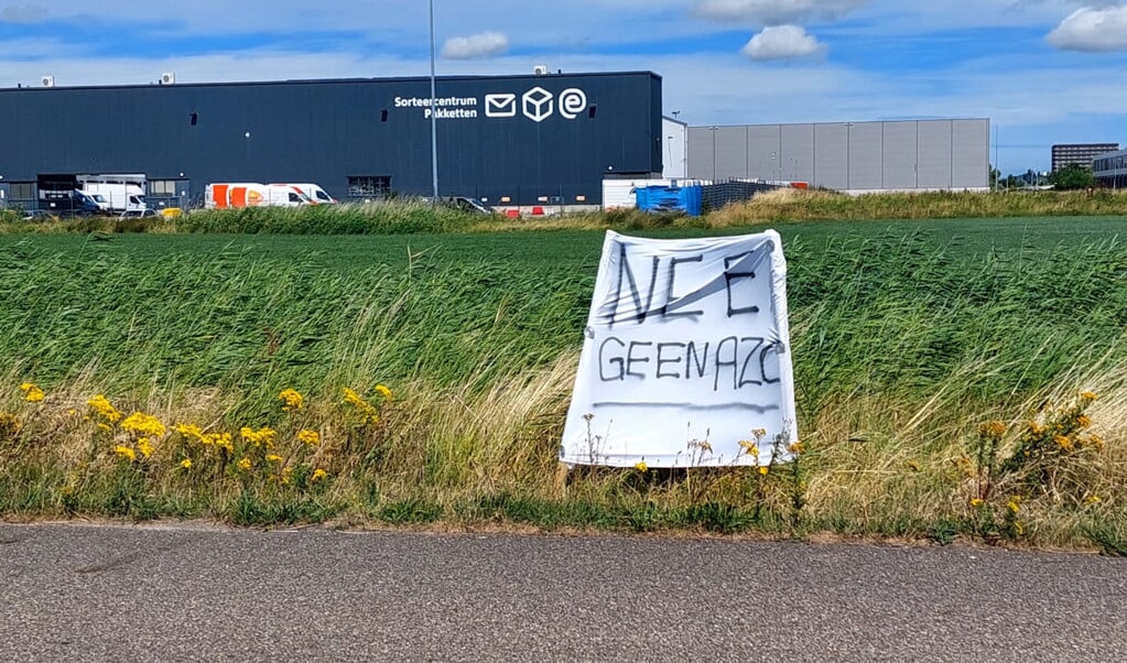 Buurtbewoners uiten hun ongenoegen over de mogelijke komst van 225 asielzoekers met een spandoek.