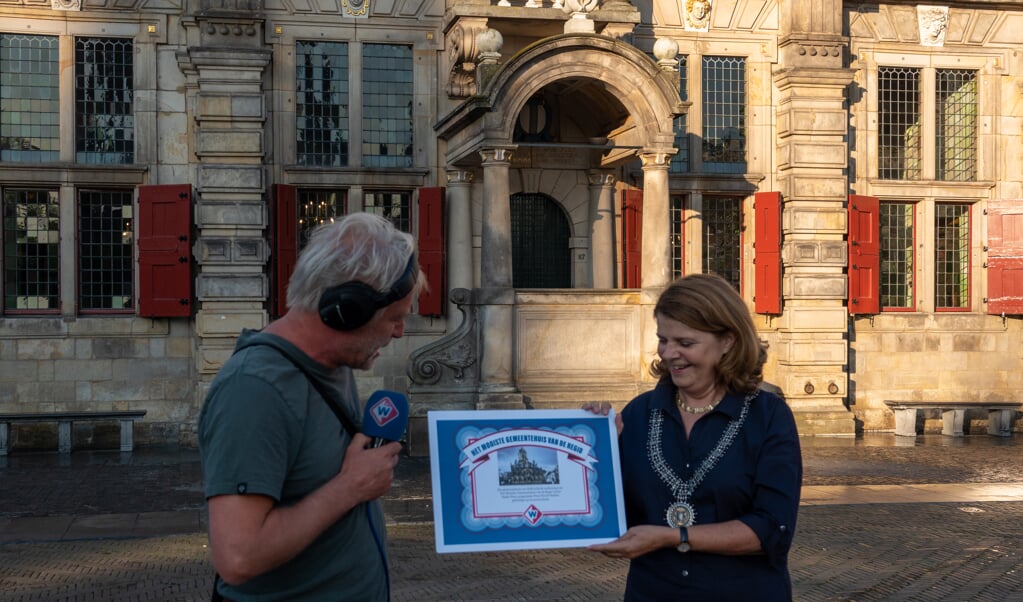Burgemeester van Bijsterveldt ontvangt van verslaggever Erik Kooyman de oorkonde voor het mooiste gemeentehuis van de regio (Foto: PR). 