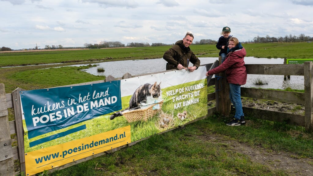 Kees, Sam en Floor hangen samen de banner op in één van de weidevogelpolders. (Foto: Ron van Bekkum)