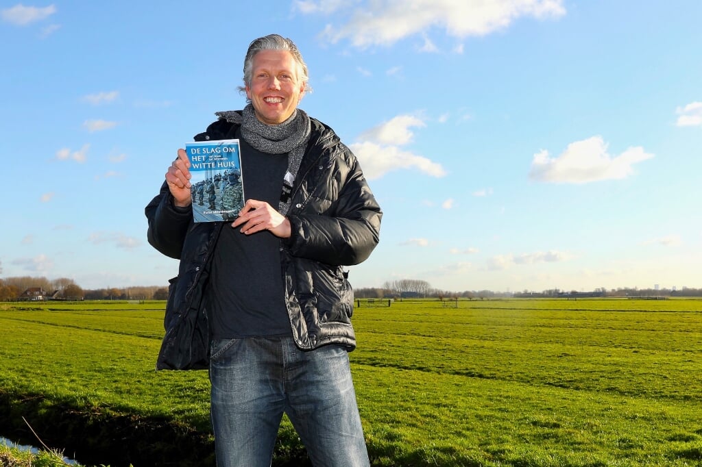 Pieter Uittenbogaard met zijn recent verschenen boek op een van de mooiste plekjes van Delft. Foto: Koos Bommelé