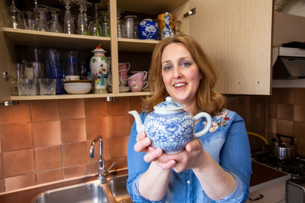 Conservator Suzanne Klüver van Museum Prinsenhof Delft met een porseleinen theepot uit haar eigen keukenkastje (Foto: Marco Zwinkels)