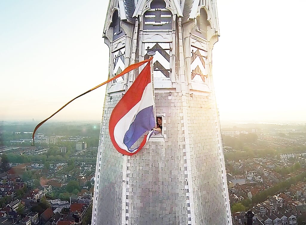 Vlaggenist Dirk Willems steekt de vlag bij de Nieuwe Kerk naar buiten (Foto: Willem de Bie)