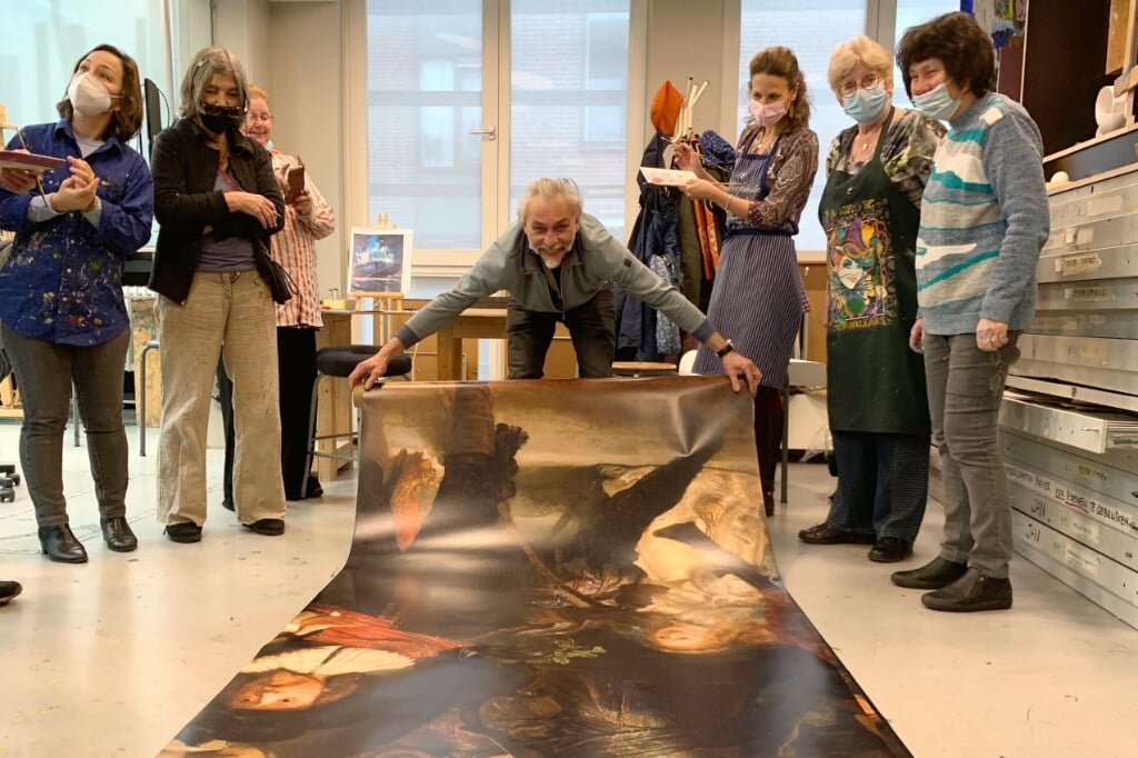 Docent Victor Roerade met print van De Nachtwacht