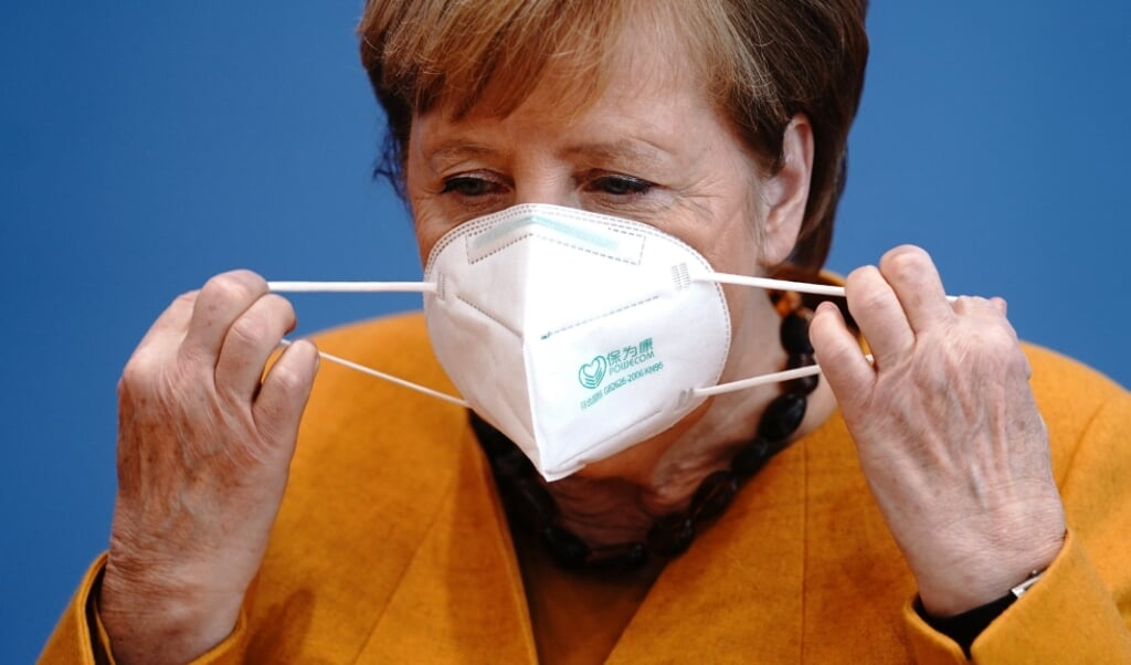 Forbundskansler Angela Merkel fjerner sin maske for at begynde på mandagens pressekonference, hvor hun appellerede til tyskerne om alle at være med til at gøre november til en