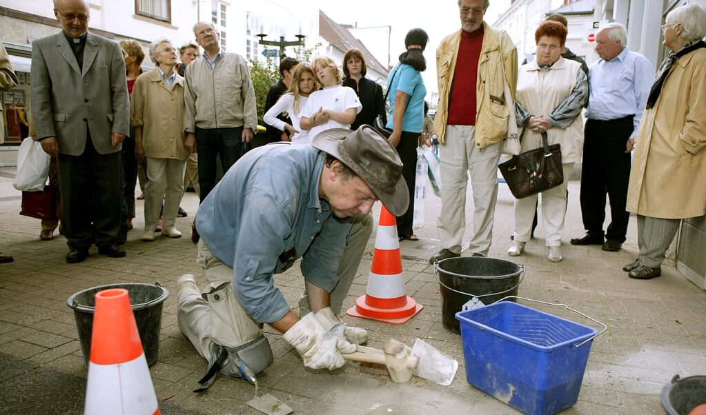 Kunstneren Gunter Demnig var flere gange på besøg i Flensborg. Her lægger han en snublesten i gågaden i Flensborg i 2004. Arkivfoto: Lars Salomonsen ( Lars Salomonsen)