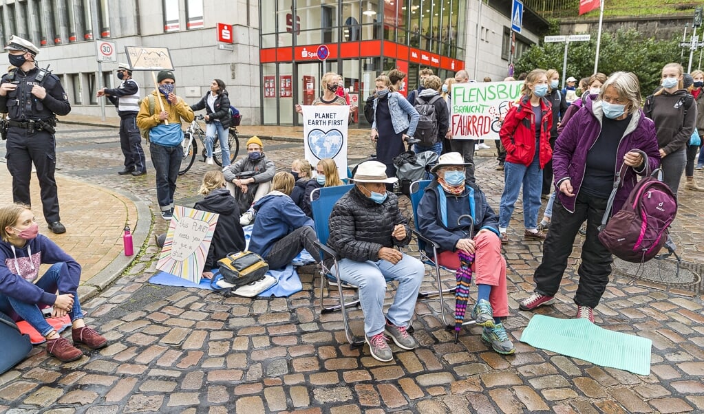 <p>På hjørnet ved banken og Stadttheater på Rådhusgade fandt deltagerne sig en bekvem plads. Biler måtte køre uden om Rådhusgade. Lars Salomonsen</p> (Lars Salomonsen)