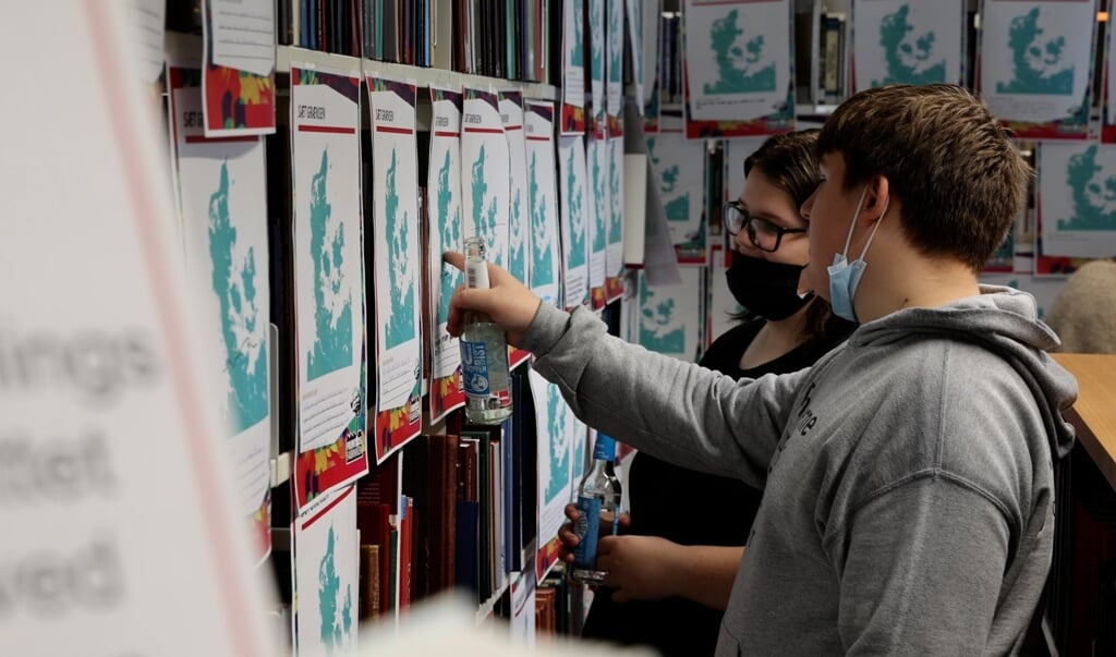 Hvem skal have hvor mange penge? De unge har været i Fremtidsfabrikken og du kan se dem over skudrene på biblioteket i Flensborg. (SdU)
