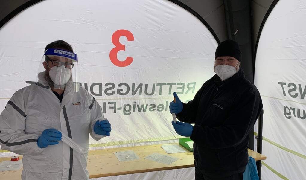 Am Dienstag nahm das Testzentrum in Schleswig seinen Betrieb auf. Hier kümmern sich Michael Zotzmann (l.) und Jens Möller mit ihren Kollegen vom Rettungsdienst des Kreises um einen reibungslosen Ablauf. ( Volker Metzger)