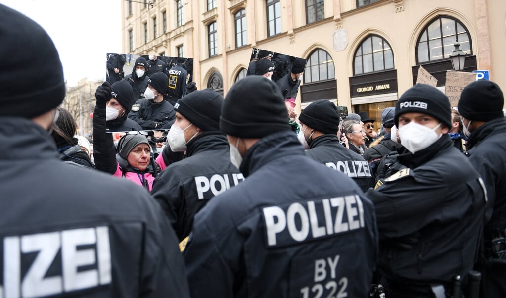 13.03.2021, Bayern, München: Eine Demonstrantin hält Polizisten bei der Demonstration gegen Maßnahmen der Bundesregierung zur Eindämmung der Corona-Ausbreitung einen Spiegel vor. Angelika Warmuth/dpa +++ dpa-Bildfunk +++ (dpa)