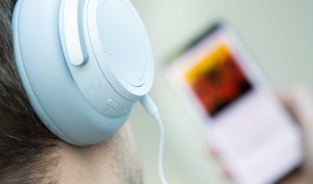 Ein Mann hört mit Kopfhörern Musik von seinem Smartphone. Dank großer Zuwächse im Audio-Streaming hat die deutsche Musikindustrie die Folgen der Corona-Pandemie beim Umsatz 2020 gut weggesteckt. (Franziska Gabbert, dpa)