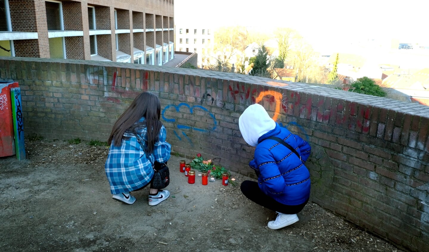 To unge piger stiller lys og blomster på udsigtsplatformen ved Duborg-Skolen.  
