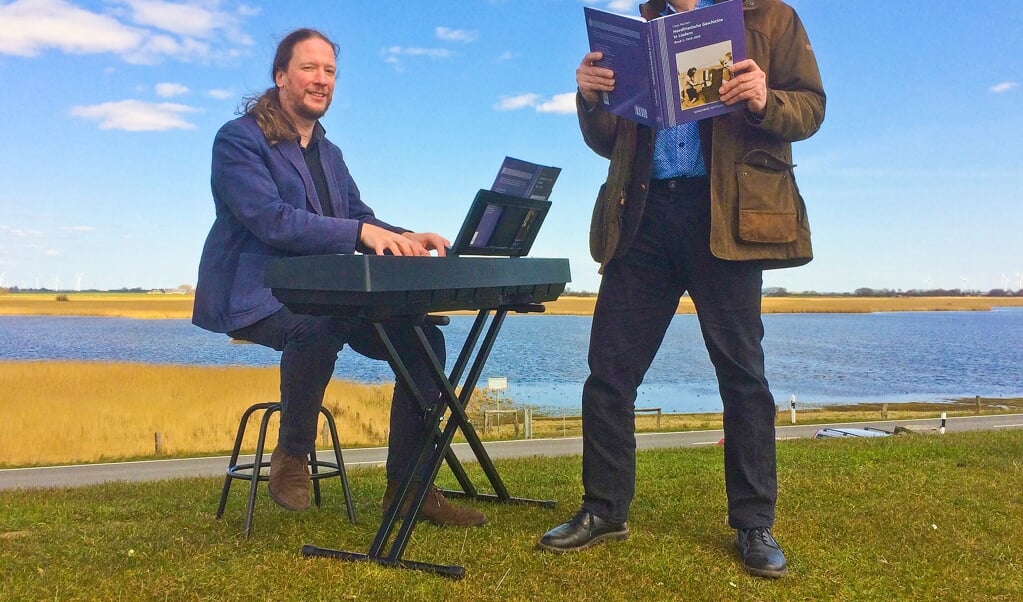 Das neue Buch des Nordfriisk Instituut erzählt anhand von Liedern nordfriesische Geschichte nach 1945. Autor Claas Riecken (rechts) und Institutsdirektor Christoph G. Schmidt präsentieren es pandemiekonform ohne Publikum auf dem Deich bei Schlüttsiel. (Franziska Böhmer)