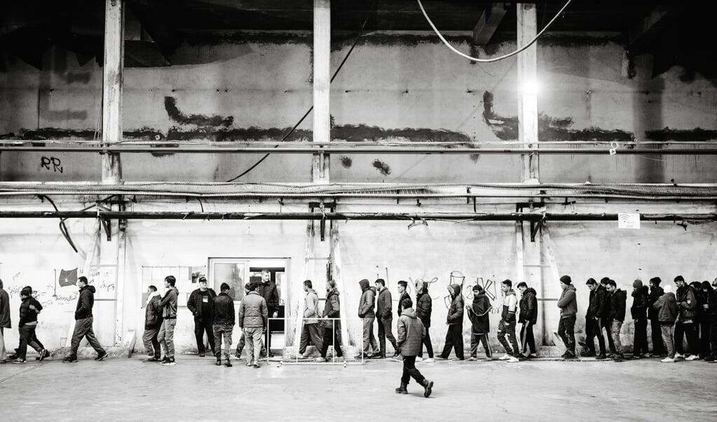 Migranter står i kø for at få mad i det midlertidige modtagecenter Bira i Bosnien. (Martin Ziemer)