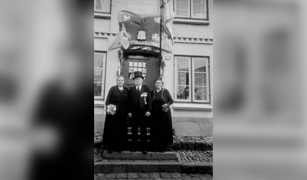 Billederne viser Julius C. E. Hansen julen 1928 og til sin 100-års fødselsdag med sin tredje kone og datteren Anna foran huset i Kalvegade, der er pyntet med husarregimentets flag. (Privat)