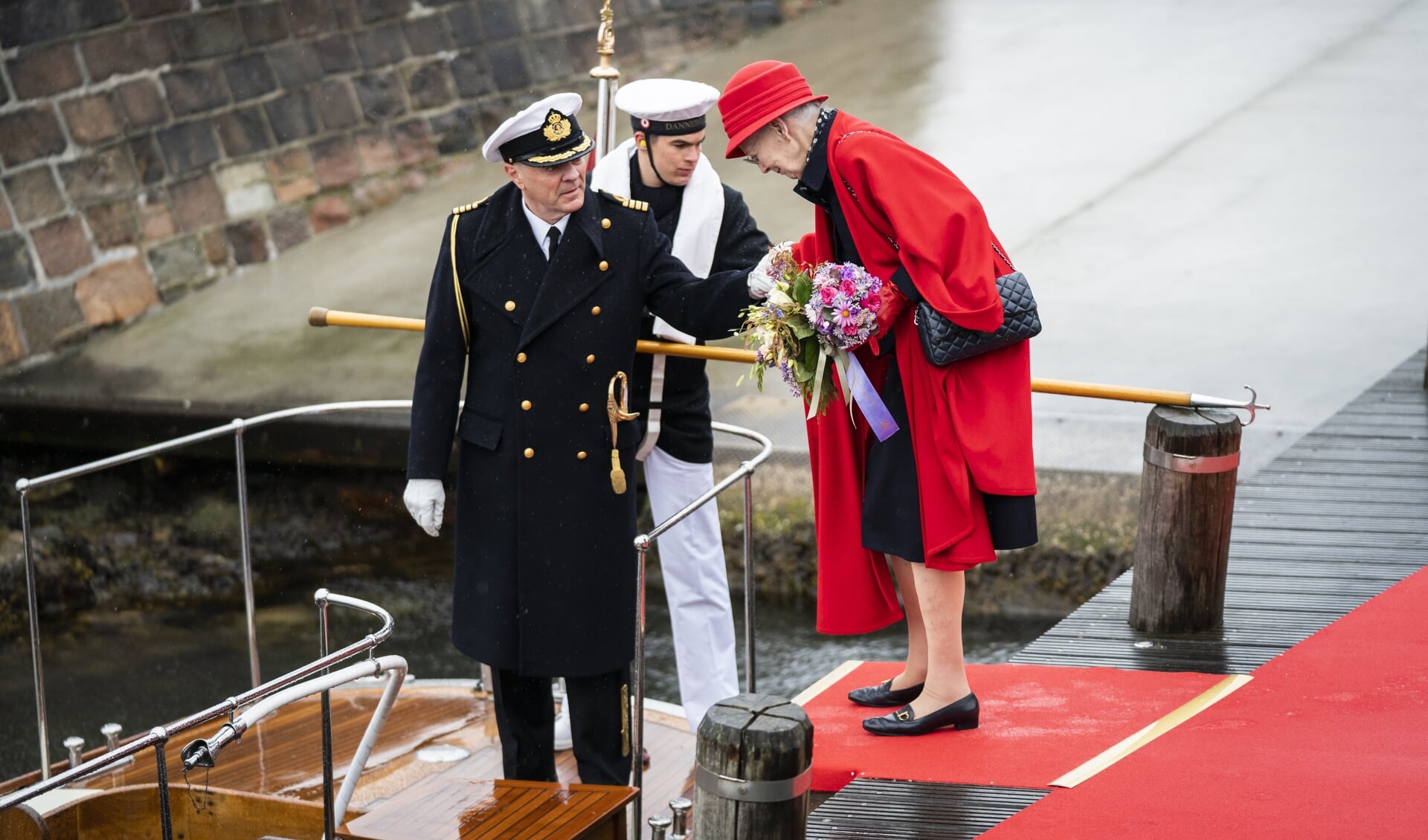 Dronning Margrethe går om bord på båden, der skal bringe hende ud til Kongeskibet. (Arkivfoto)