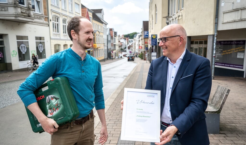 Ole Lebendig (t.v.) får en klimapris for sin Leihladen Flensburg, som han gerne vil åbne i Angelbogade. Til højre Jürgen Möller fra SBV, som er Klimapakt-formand. (Martin Ziemer)