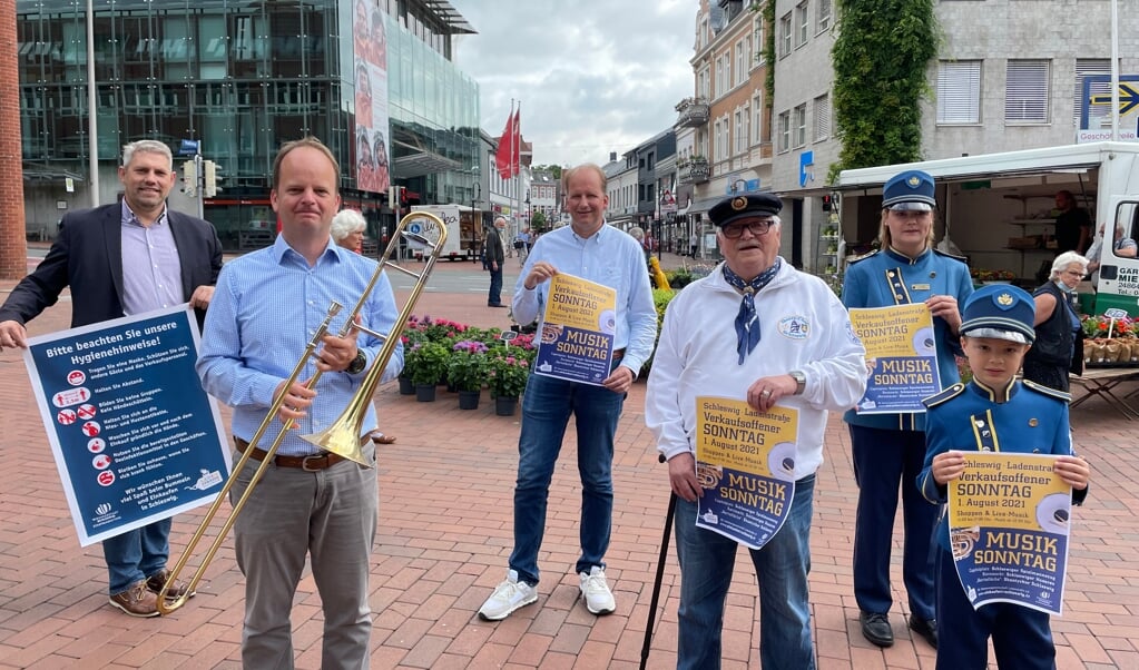 Helge Schütze (Stadtmanager), Sönke Matz (Posaunen-Chor), Thomas Forch (IG Ladenstraße), Peter Stremlau (Chanty Chor Schleswig) sowie Julia und Luka Behrendsen (Spielmannszug Schleswig) (v.l.) freuen sich auf den 1. verkaufsoffenen Sonntag in diesem Jahr. (Volker Metzger)