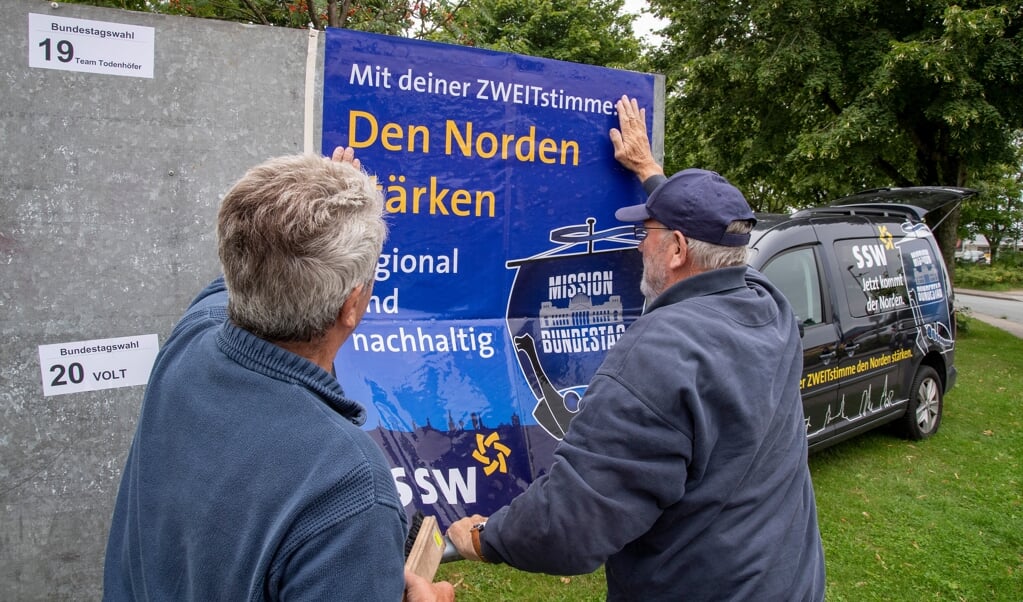 »Den Norden stärken - regional und nachhaltig« står der på den plakat, Uwe Jacobsen (kasket) og Bruno Wöhlk satte op i Sporskifte forud for forbundsdagsvalget. Nu går sloganet igen i en liste over krav, som SSW stiller til den nye forbundsregering. (Arkivfoto: Tim Riediger)