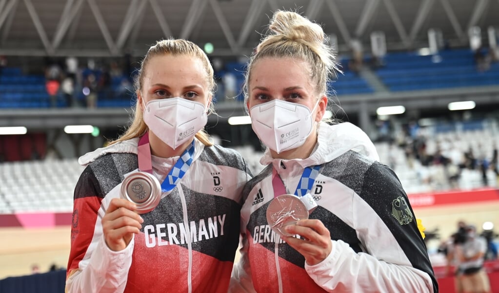 Silbermedaillengewinnerinnen Lea Sophie Friedrich (r) aus Deutschland und Teamkollegin Emma Hinze aus Deutschland zeigen nach der Siegerehrung ihre Medaillen. (Sebastian Gollnow/dpa)
