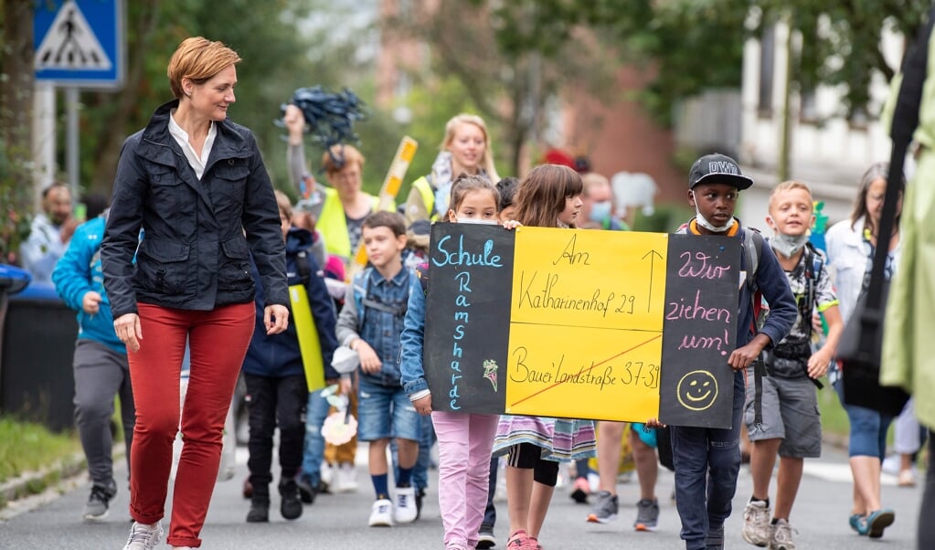 Med et skilt viste eleverne, hvor de var på vej hen, da de fik lov at gå på vejen hen mod den nye skole. (Kira Kutscher)