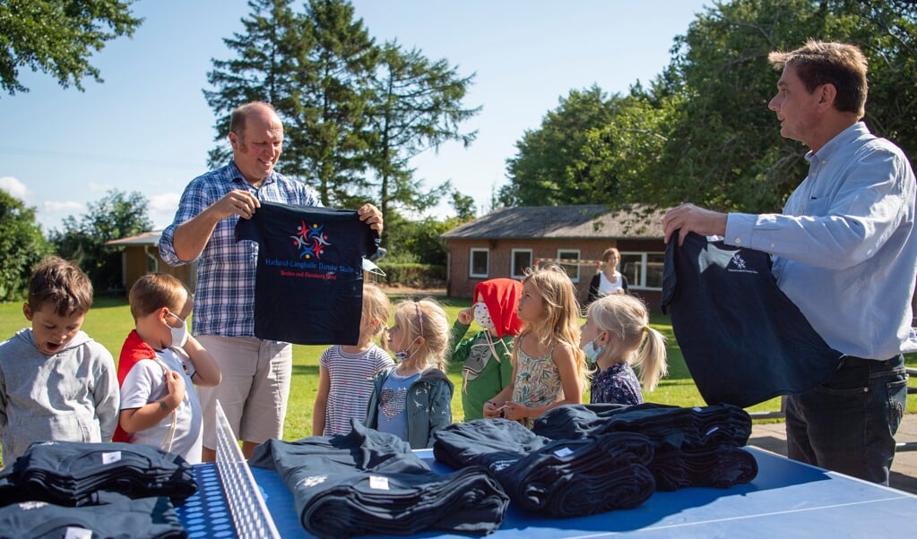 Hatlund-Langballe Danske Skole bliver tit glemt, når Stenbjergkirke Kommune giver noget til skoler, mener Jürgen Schiewer (t.h.), der med hjælp fra skoleleder Klaus Andersen onsdag delte t-shirts ud til hele skolen. ( Kira Kutscher)