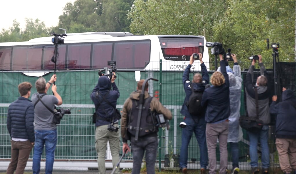 18.08.2021, Hamburg: Ein Bus, mit dem Menschen aus Frankfurt gekommen und die zuvor aus Afghanistan evakuiert wurden, steht auf dem Gelände einer Aufnahmeeinrichtung. Zahlreiche Journalisten stehen vor der Einrichtung. Die ersten aus Kabul ausgeflogenen afghanischen Ortskräfte sind am frühen Abend in einer Aufnahmeeinrichtung in Hamburg eingetroffen.  Bodo Marks/dpa +++ dpa-Bildfunk +++  (dpa)