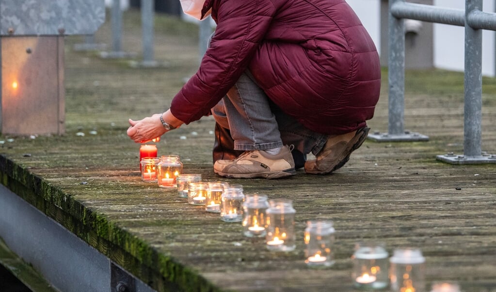 Flakkende stearinlys bliver placeret én efter én langs molen ved Obereiderhafen i Rendsborg. Corona har taget livet af mange, og lysene skal mindes dem, der har mistet livet.   (Tim Riediger)