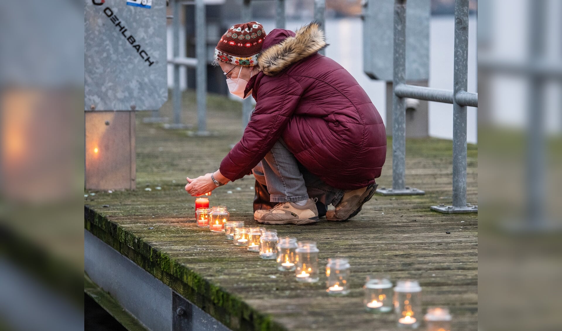 Flakkende stearinlys bliver placeret én efter én langs molen ved Obereiderhafen i Rendsborg. Corona har taget livet af mange, og lysene skal mindes dem, der har mistet livet. Foto:
