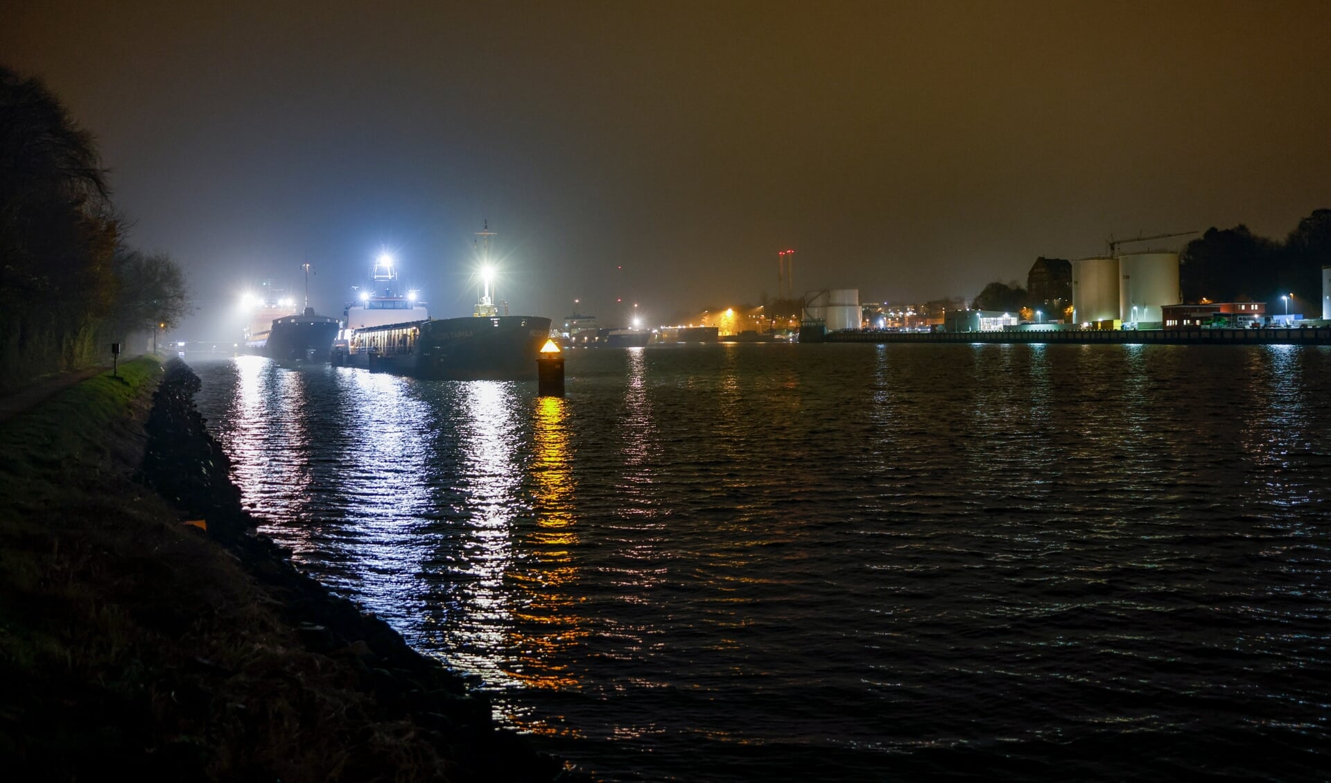 Schiffe warten im Nord-Ostsee-Kanal auf die Durchfahrt der Hochbrücke in Kiel-Holtenau. Ein Schiff war mit der Brücke kollidiert, worauf hin diese für den Schiffs- und Autoverkehr gesperrt wurde. Foto: