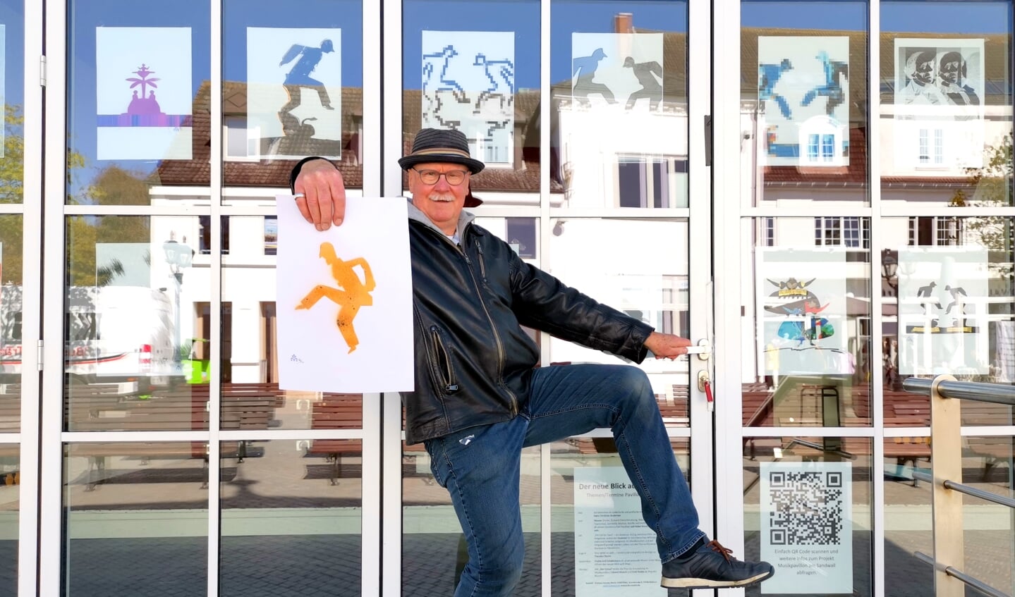 Andreas Petzold alias PAN vor dem Musikpavillon in Wyk auf Föhr mit seinen Arbeiten auf der Grundlage von Hans Christian Andersen Scherenschnitten. Foto: