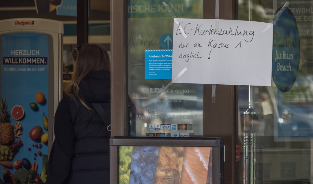 An der Eingangstür einer Filiale des Lebensmitteldiscounters Aldi Nord hängt ein handgeschriebener Zettel mit der Aufschrift: EC-Kartenzahlung nur an Kasse 1 möglich!   ( Georg Hilgemann/dpa)