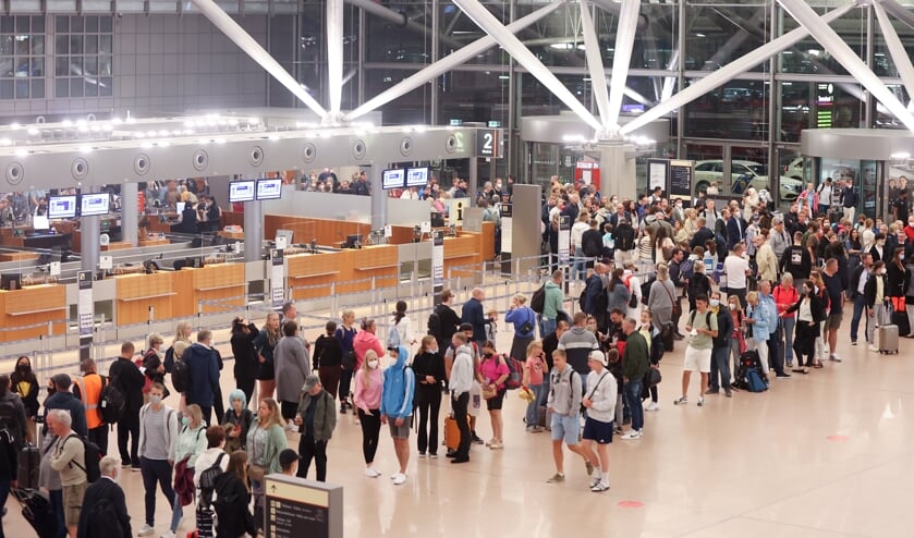 Zahlreiche Reisende stehen am Morgen in einer Schlange im Terminal 1 an, die zur Sicherheitskontrolle am Hamburger Flughafen führt. In Hamburg haben die Ferien begonnen. Foto: 