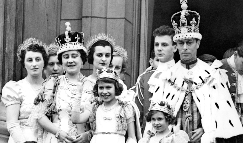 Den nye kongefamilie træder ud på balkonen på Buckingham Palace 12. maj 1937 efter kroningen af Elizabeths far, kong George VI. Det er Elizabeth, der vinker. Til venstre Elizabeths mor, der også hed Elizabeth. Til højre hendes lillesøster, Margaret, og hendes far, kong George VI.