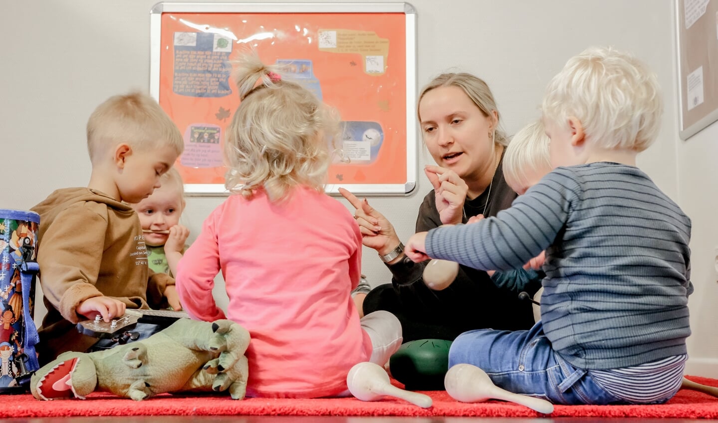 Pædagog Morlin Marxen er i gang med et musikprojekt med børnene i Karlsson Vuggestue, hvor børnene blandt andet har lavet deres egne instrumenter. Foto: