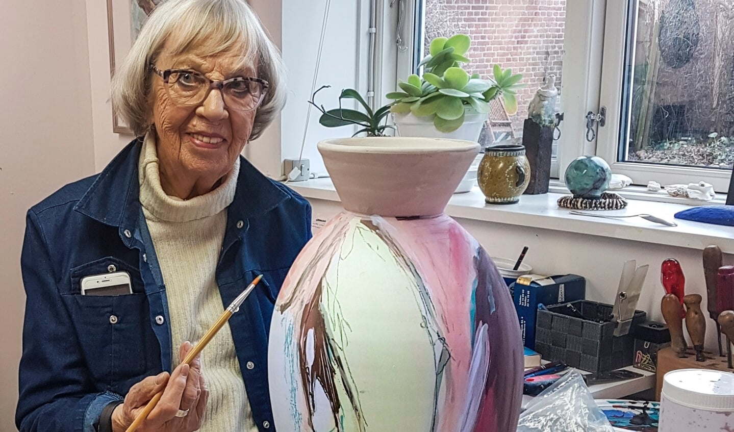 Grete Balle er her i gang med at dekorere en høj klassisk krukke drejet af keramiker Bjarne Puggaard. Foto: 