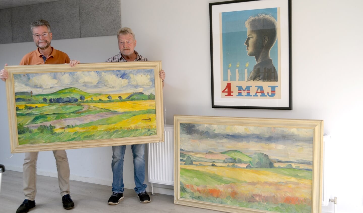 Formand Michael Longerich, til venstre, og kollegiets efor Ove Fonnesbæk viser er de to Peter Nicolaisen-værker frem. Håbet er, at de to malerier kommer til ære og værdighed igen ved at blive hængt op i fællessalen.