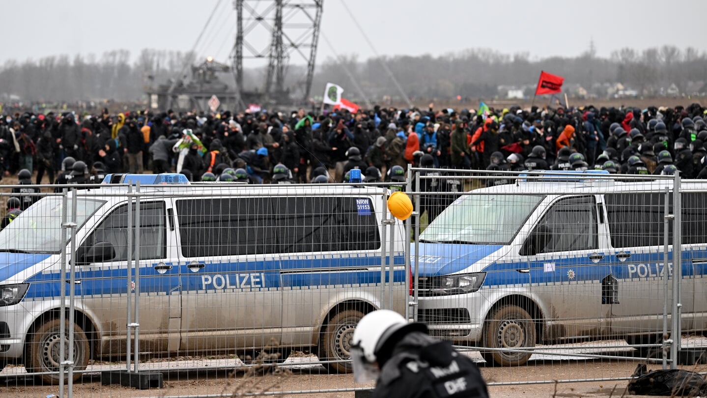 Politi og demonstranter foran hegnet, der er blevet stillet op rundt om Lützerath. Foto: