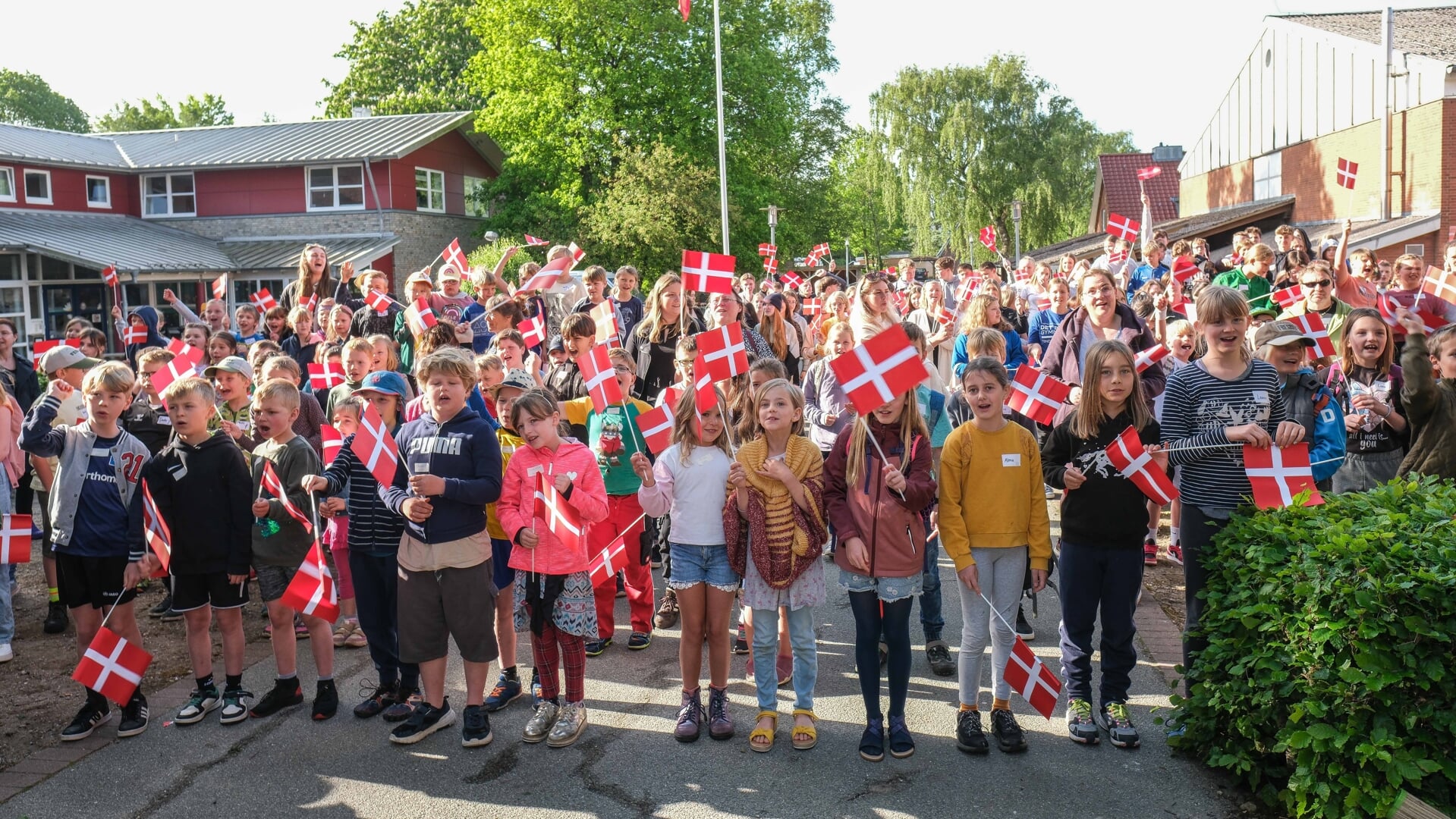 Næsten 260 elever på Husum Danske Skole - hver med et flag i hånden - tog torsdag morgen hul på fejringen af deres skoles 75-års fødselsdag. Foto: