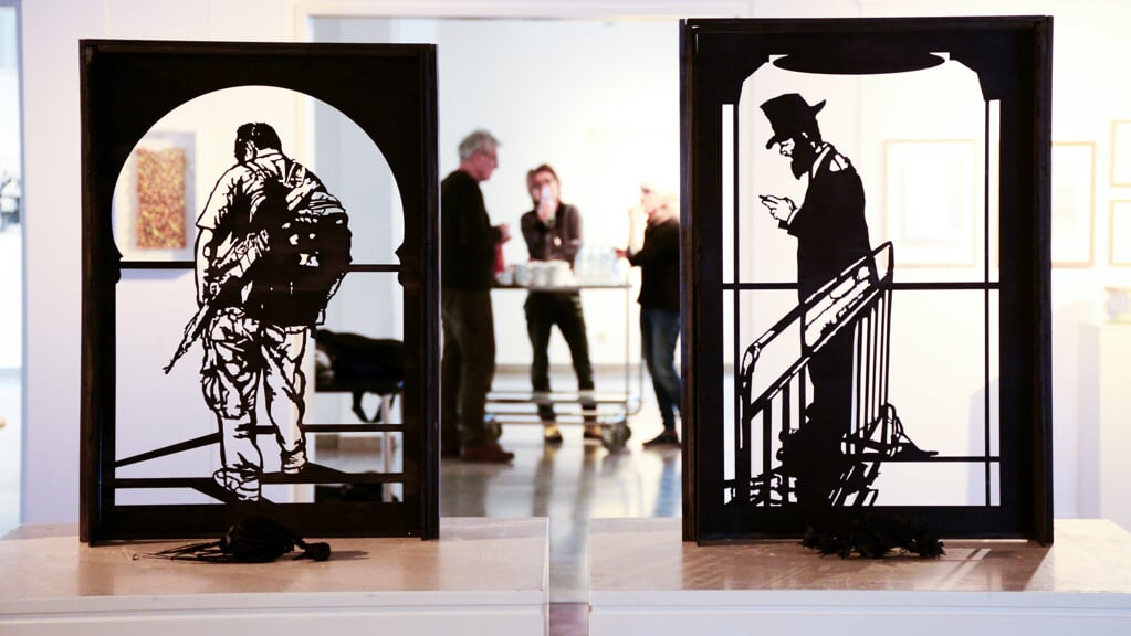 Steen Rasmussens udskæringer står som sorte silhouetter midt på udstillingen på Flensborg Bibliotek. Motiverne er hentet i Israel og Palæstina. Foto: